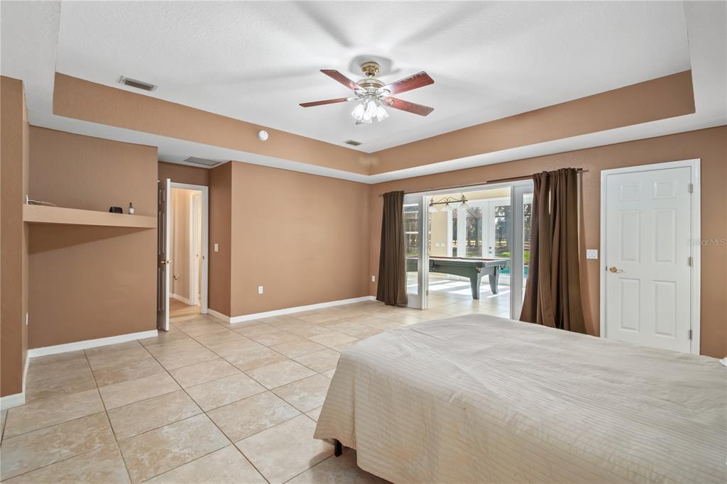 1969 Northwest 111th Loop Ocala, FL 34475 - Photo 38 of 48 a bedroom with a large bed and a chandelier