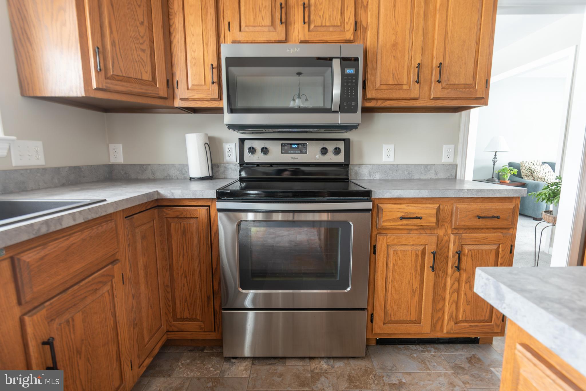 1469 Chaumont Avenue State College, PA 16801 - Photo 11 of 50 a kitchen with granite countertop a stove top oven microwave and cabinets