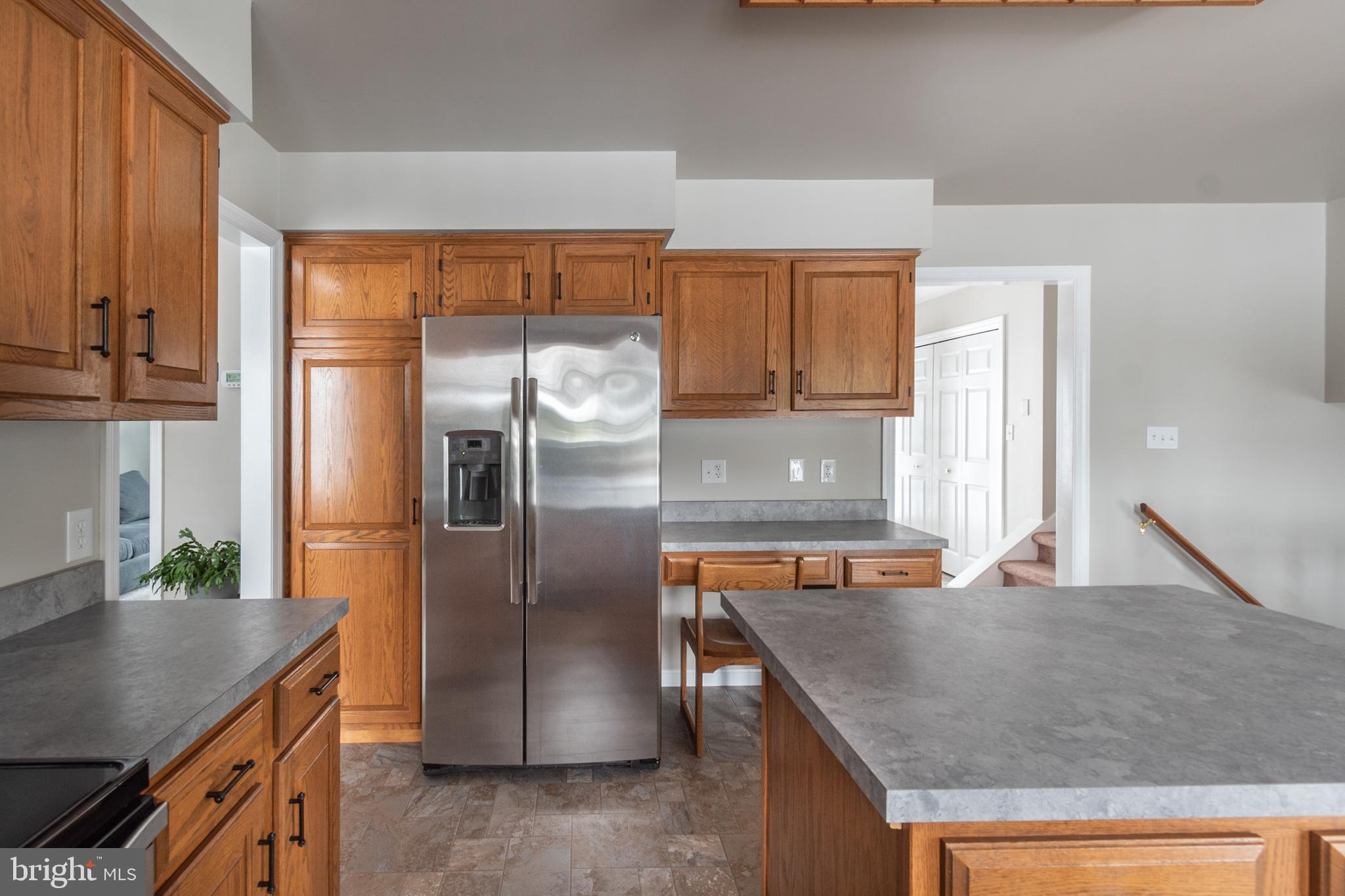 1469 Chaumont Avenue State College, PA 16801 - Photo 12 of 50 a kitchen with stainless steel appliances granite countertop a refrigerator a stove and a sink with wooden cabinets