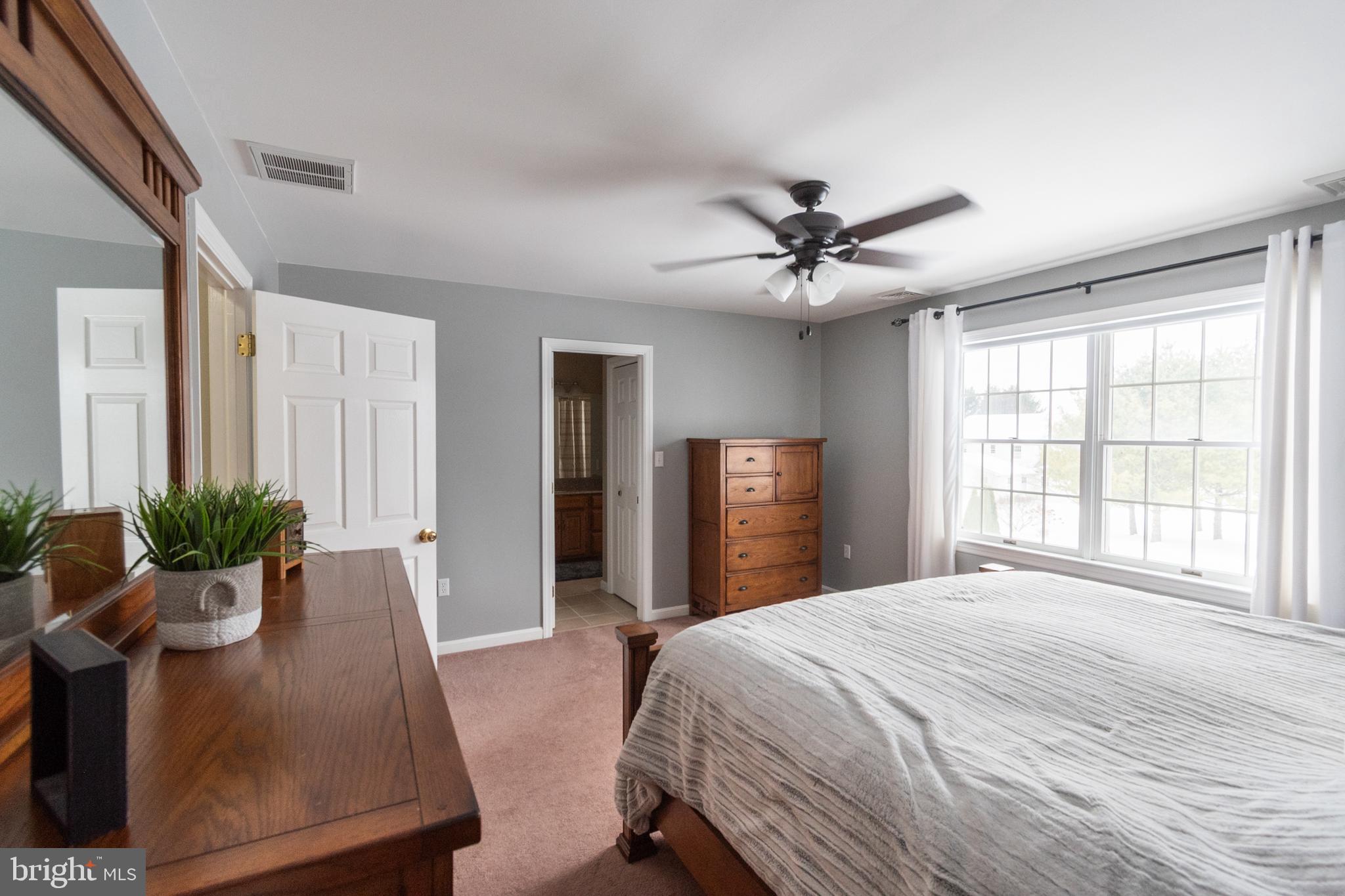 1469 Chaumont Avenue State College, PA 16801 - Photo 25 of 50 a spacious bedroom with a large bed and a chandelier