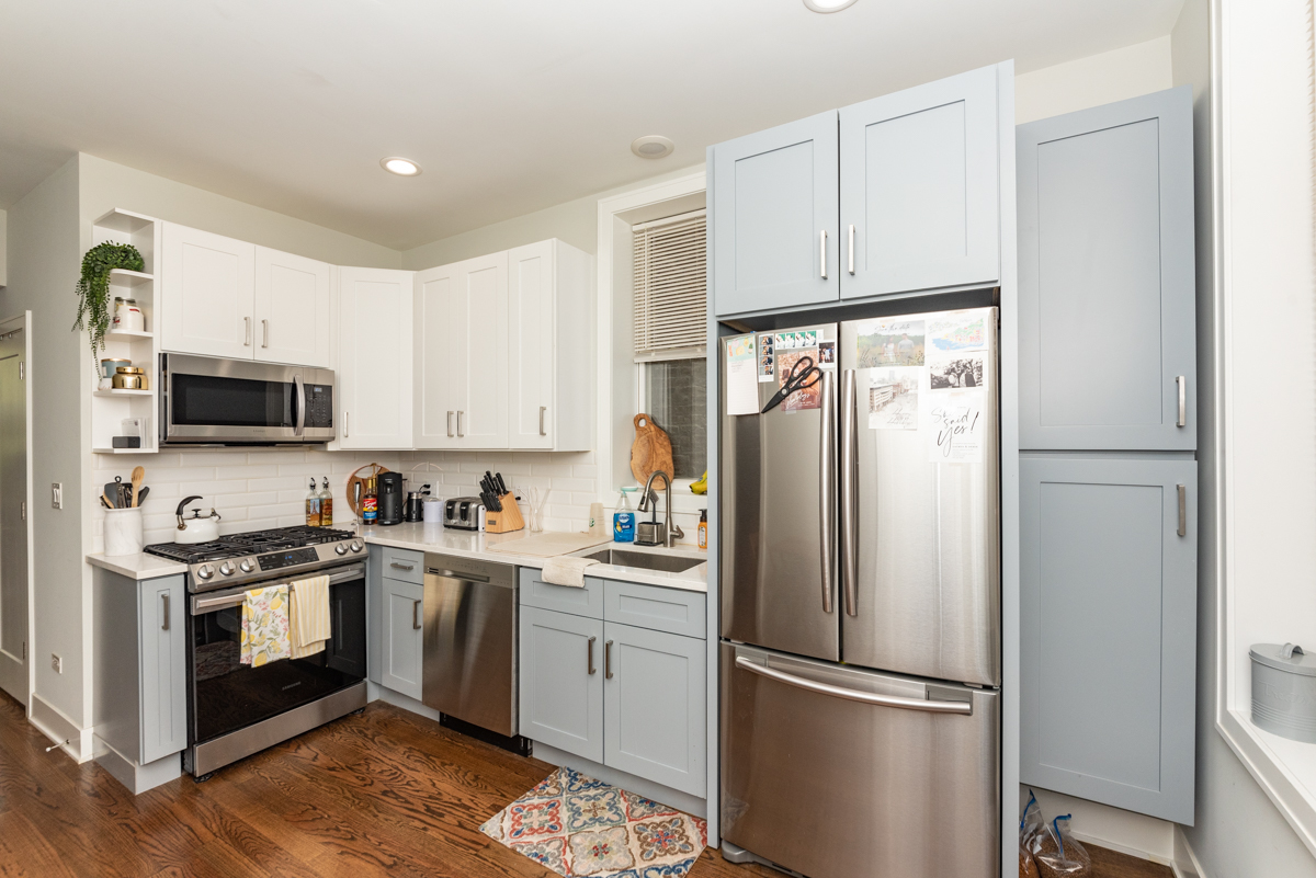 2145 West Webster Avenue, Unit 2 Chicago, IL 60647 - Photo 2 of 13 a kitchen with stainless steel appliances granite countertop a refrigerator stove a sink and white cabinets with wooden floor