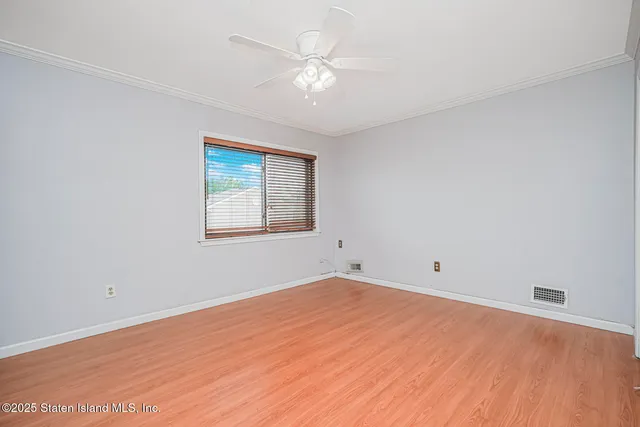 an empty room with a window and a fan