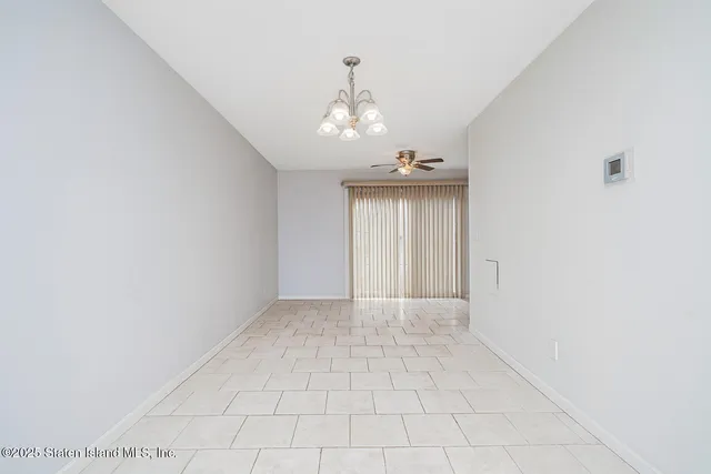 an empty room with chandelier and windows