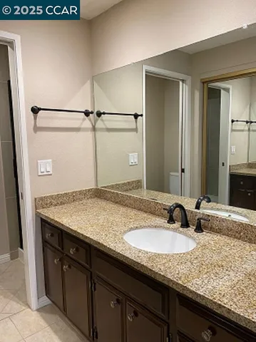 a bathroom with a granite countertop sink and a mirror