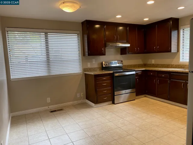 a kitchen with stainless steel appliances granite countertop a sink and a stove