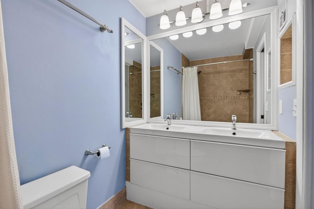 1759 Northeast 40th Place, Unit 604 Pompano Beach, FL 33064 - Photo 13 of 24 a bathroom with a sink a toilet and mirror