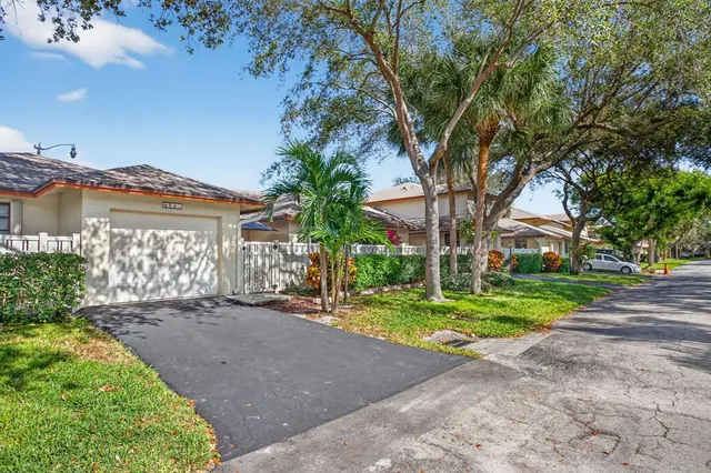 a view of a house with a yard and large trees