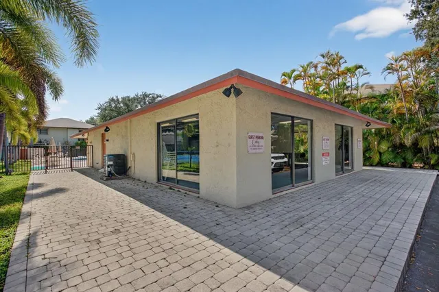 a front view of house with yard and trees in the background