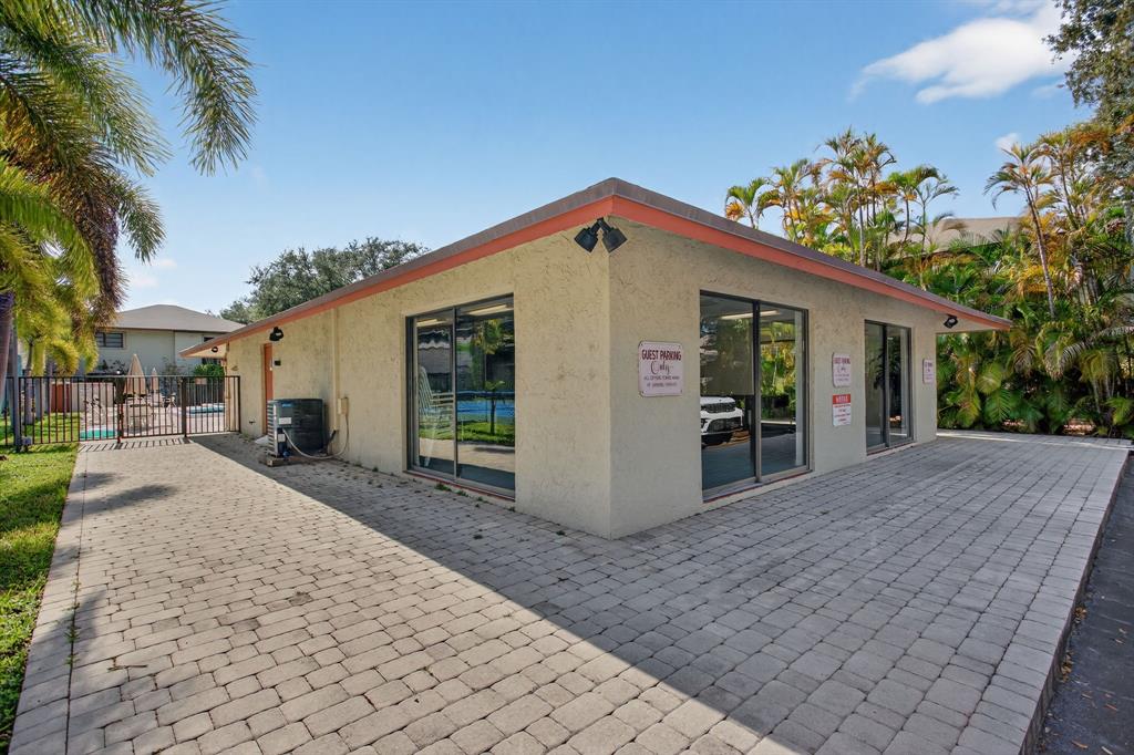 1759 Northeast 40th Place, Unit 604 Pompano Beach, FL 33064 - Photo 23 of 24 a front view of house with yard and trees in the background