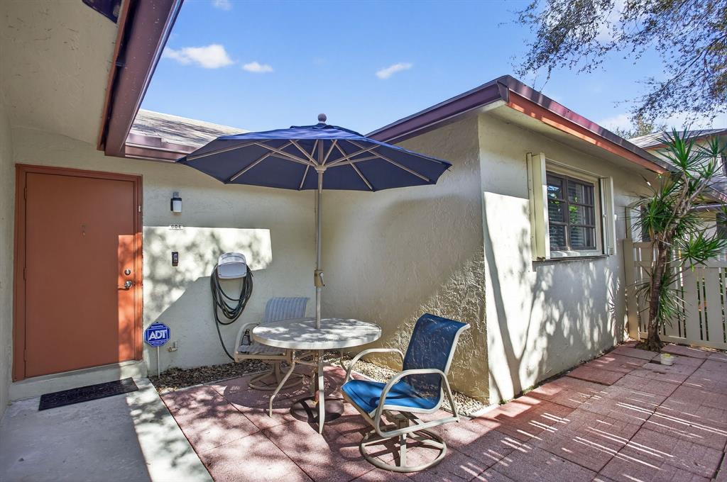 1759 Northeast 40th Place, Unit 604 Pompano Beach, FL 33064 - Photo 3 of 24 a table and chairs in the patio