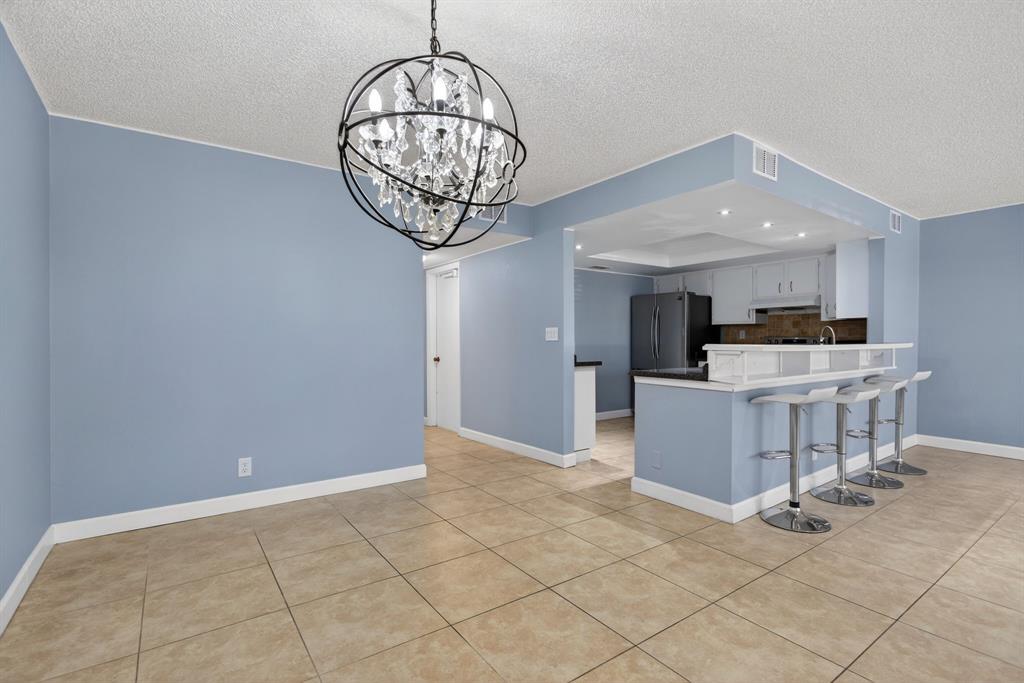 1759 Northeast 40th Place, Unit 604 Pompano Beach, FL 33064 - Photo 5 of 24 a view of a dining room and chandelier