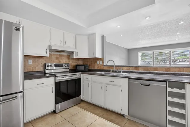 a kitchen with granite countertop white cabinets and white appliances