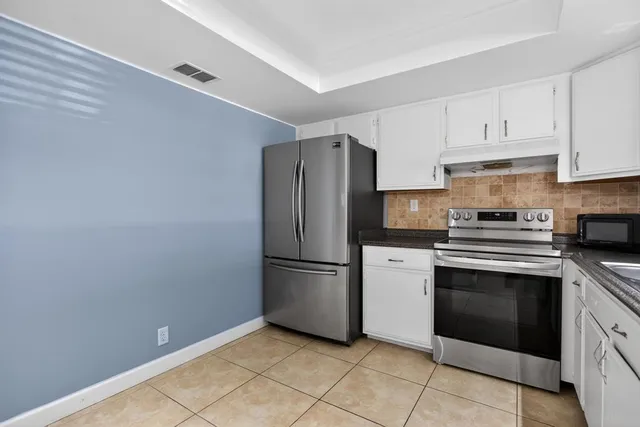 a kitchen with a stove top oven and refrigerator