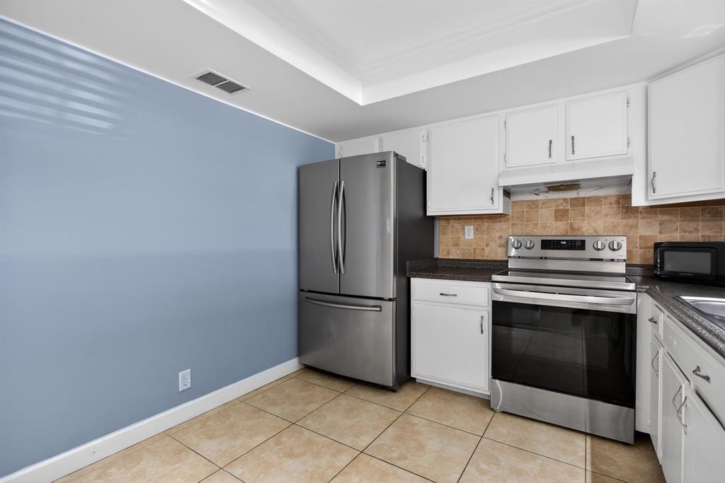 1759 Northeast 40th Place, Unit 604 Pompano Beach, FL 33064 - Photo 9 of 24 a kitchen with a stove top oven and refrigerator