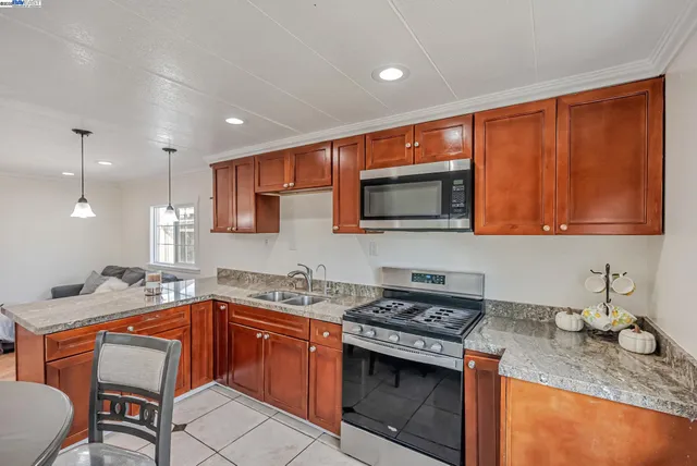 a kitchen with stainless steel appliances granite countertop a sink stove and microwave