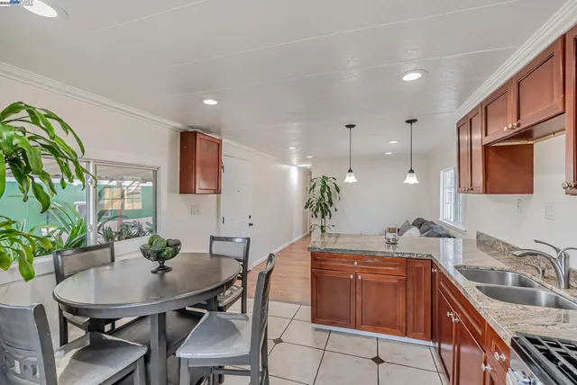 a kitchen with a table chairs sink and cabinets