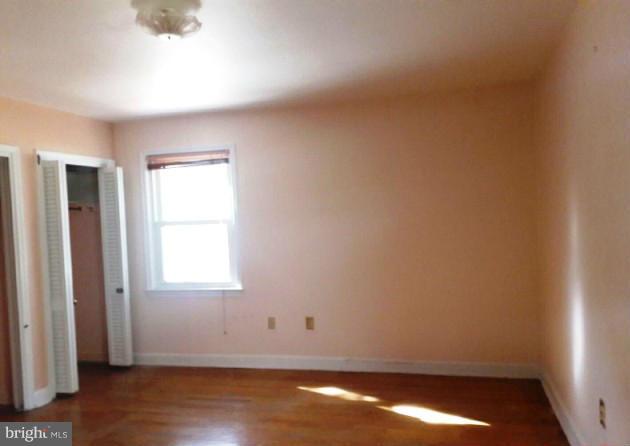 500 Blick Drive Silver Spring, MD 20904 - Photo 7 of 15 an empty room with wooden floor and windows with curtains