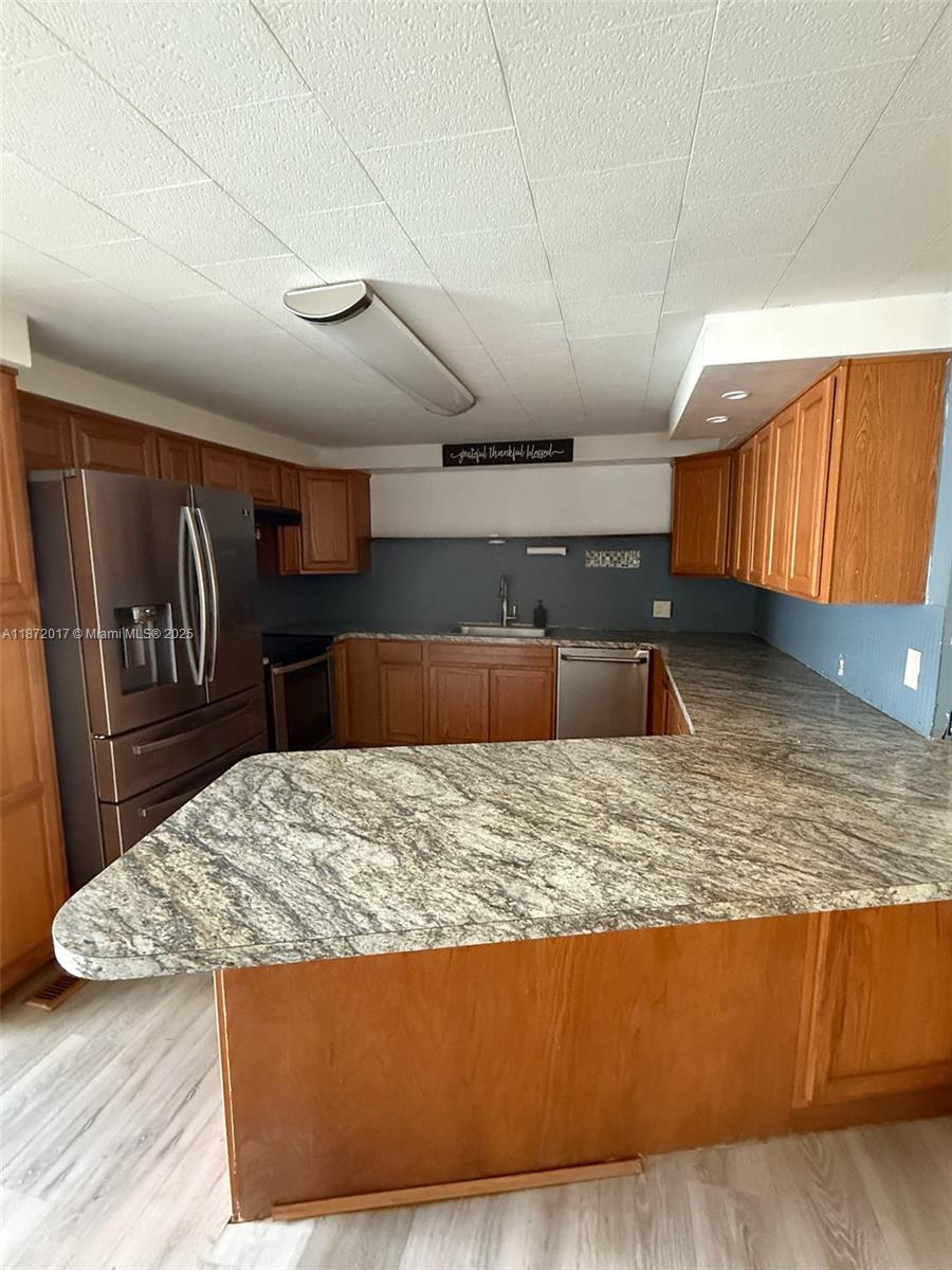 5374 Southeast Celestial Circle Stuart, FL 34997 - Photo 4 of 23 a living room with kitchen countertops and a wooden floor