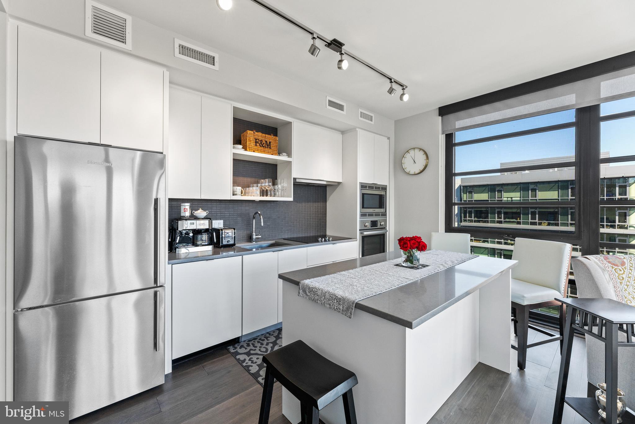 1300 4th Street Southeast, Unit 915 Washington, DC 20003 - Photo 5 of 34 a kitchen with a refrigerator a stove a sink dishwasher and white cabinets with wooden floor