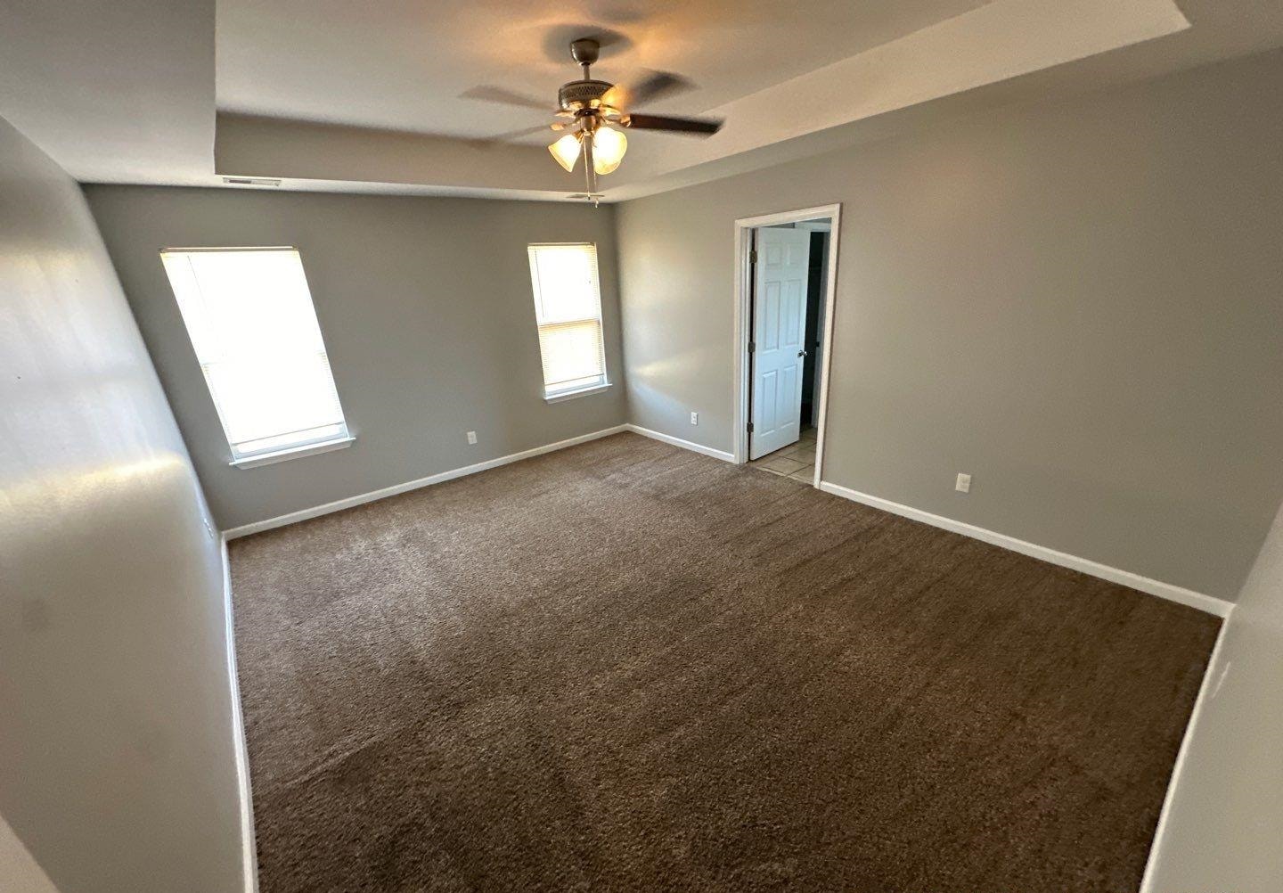 9420 Grove Road Cordova, TN 38016 - Photo 9 of 15 Empty room with a raised ceiling, ceiling fan, and dark carpet