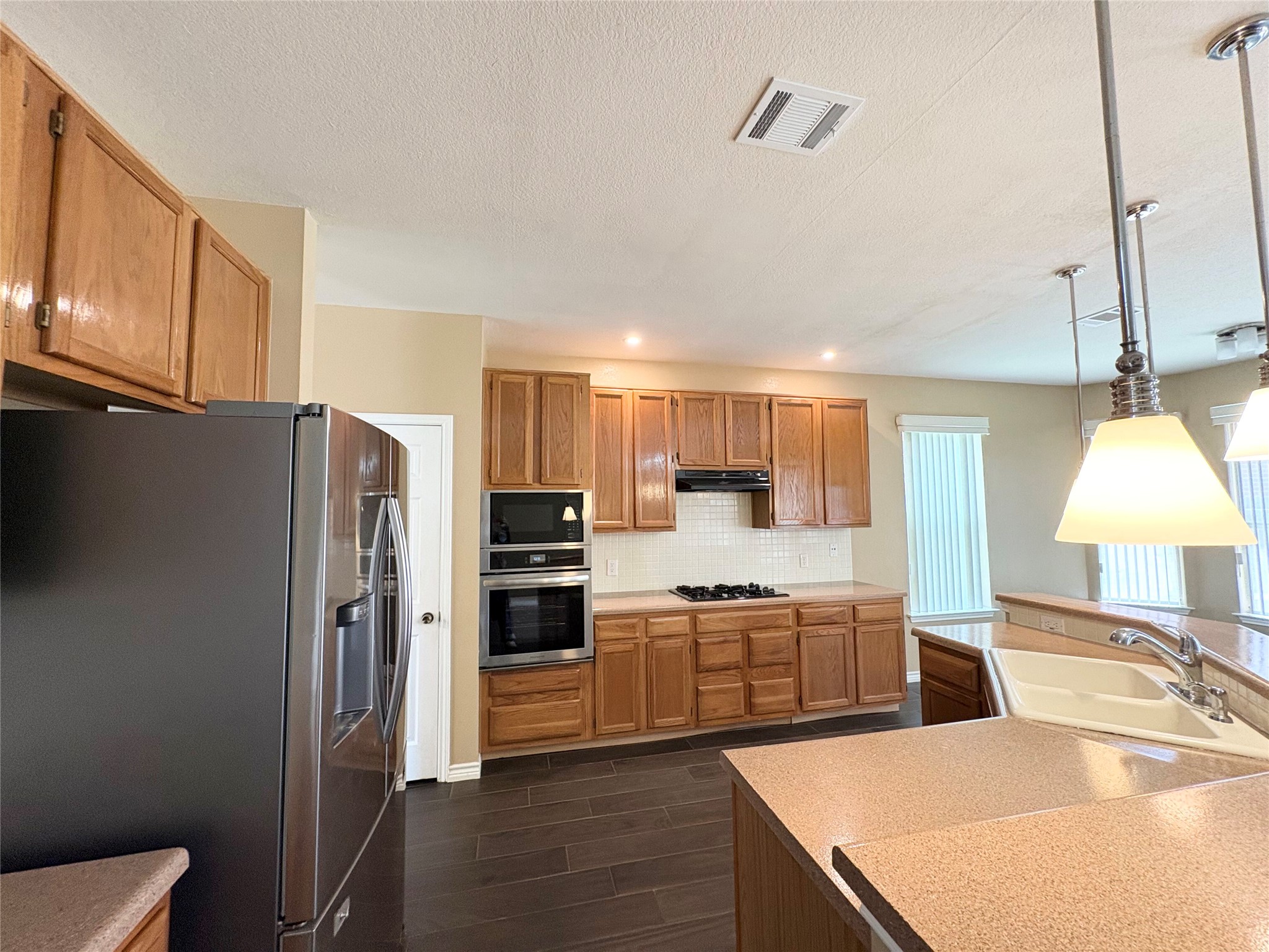 8103 Ephraim Road Austin, TX 78717 - Photo 12 of 35 Culinary adventures await in this kitchen featuring abundant wood cabinetry and sleek appliances.