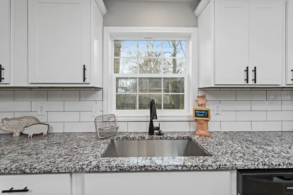a kitchen with granite countertop a sink and a window