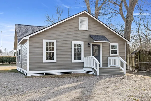 a front view of a house with a yard and seating space