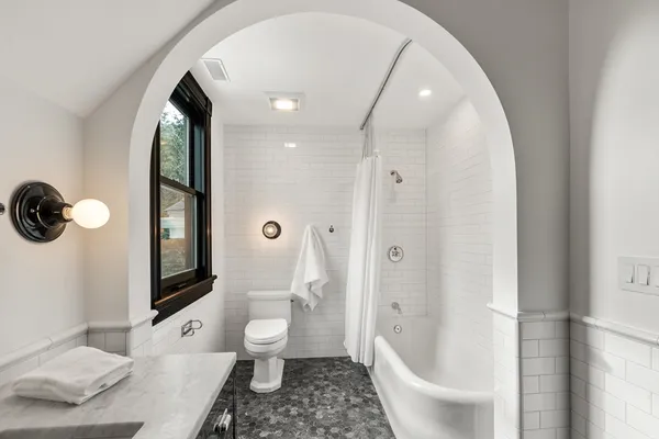 a bathroom with a sink a toilet and a large mirror