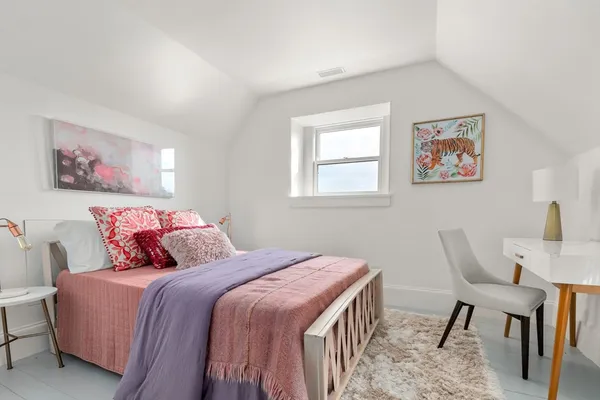 a bedroom with a large bed and a chair
