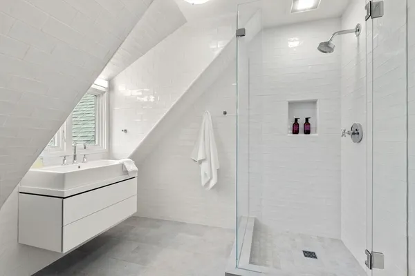 a bathroom with a shower a sink and a mirror