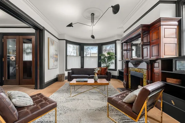a living room with furniture a fireplace and a chandelier