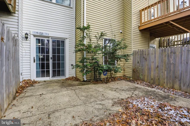 a view of a house with a door and wooden fence