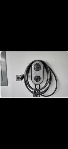 a view of a backyard with large trees and wooden fence