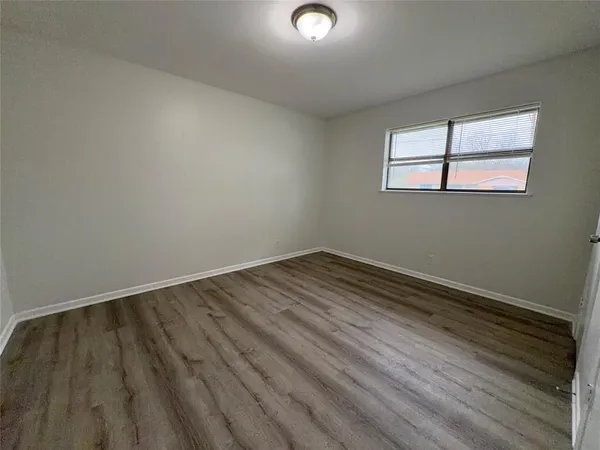 a view of a room with wooden floor and window