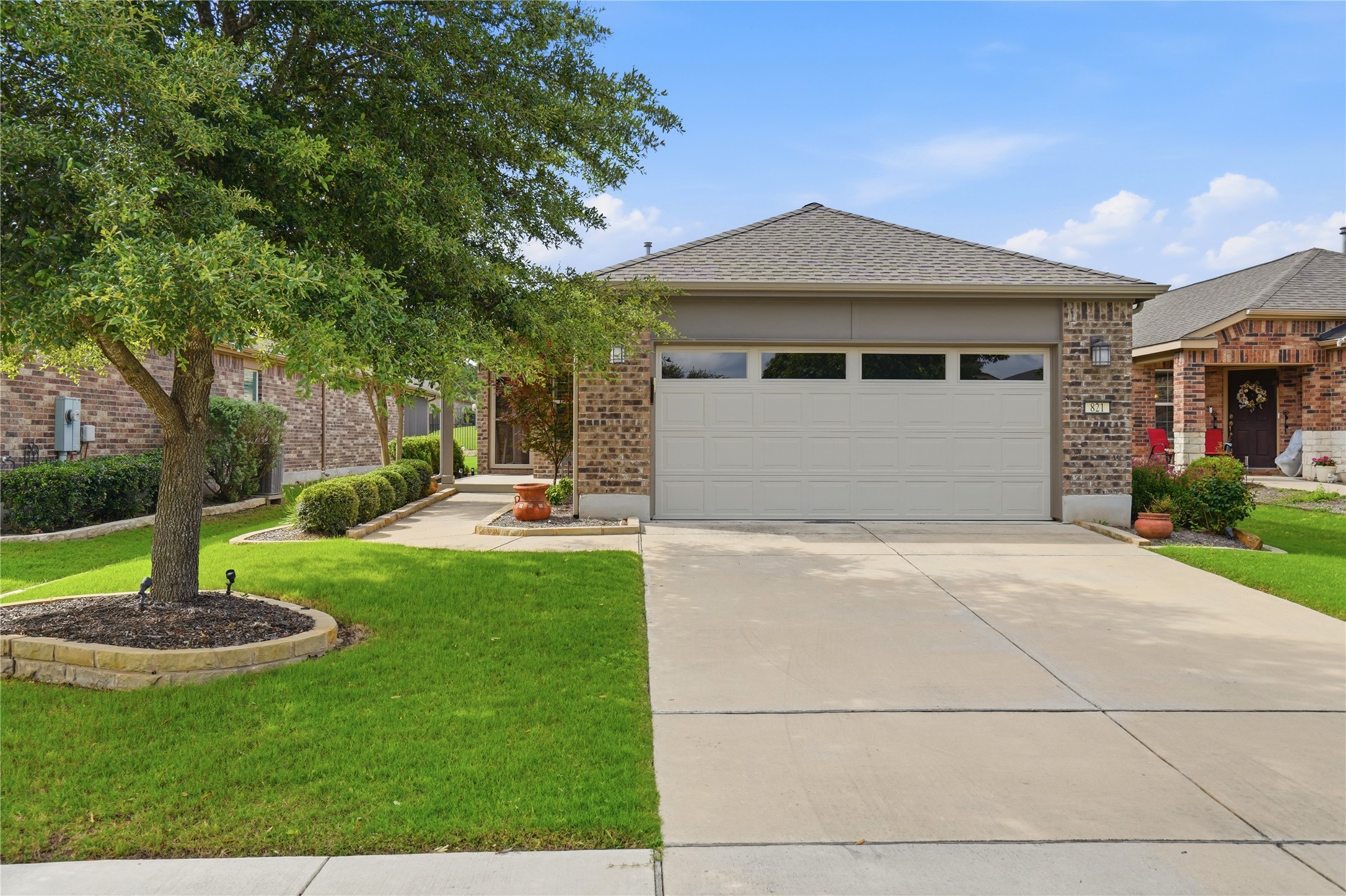 821 Hamilton Lane Georgetown, TX 78633 - Photo 1 of 38 Brick home featuring a two-car garage and a front yard with mature trees