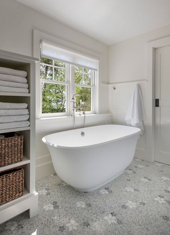 23 University Lane Manchester, MA 01944 - Photo 25 of 40 a white bath tub sitting in a bathroom next to a window