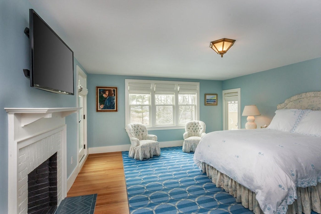 23 University Lane Manchester, MA 01944 - Photo 26 of 40 a bedroom with a bed and a flat screen tv