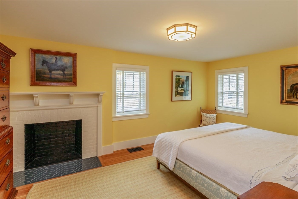 23 University Lane Manchester, MA 01944 - Photo 28 of 40 a bedroom with a bed and a fireplace