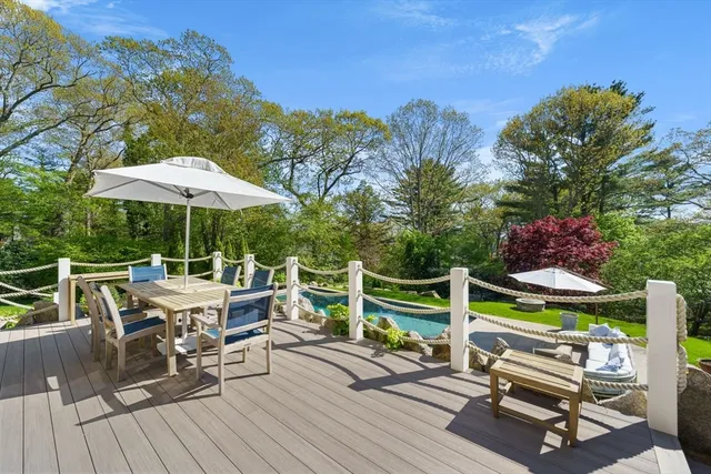 a view of backyard with seating space and trees in the background