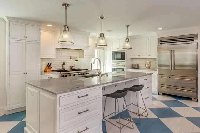 a kitchen with kitchen island granite countertop stainless steel appliances a sink a counter and cabinets