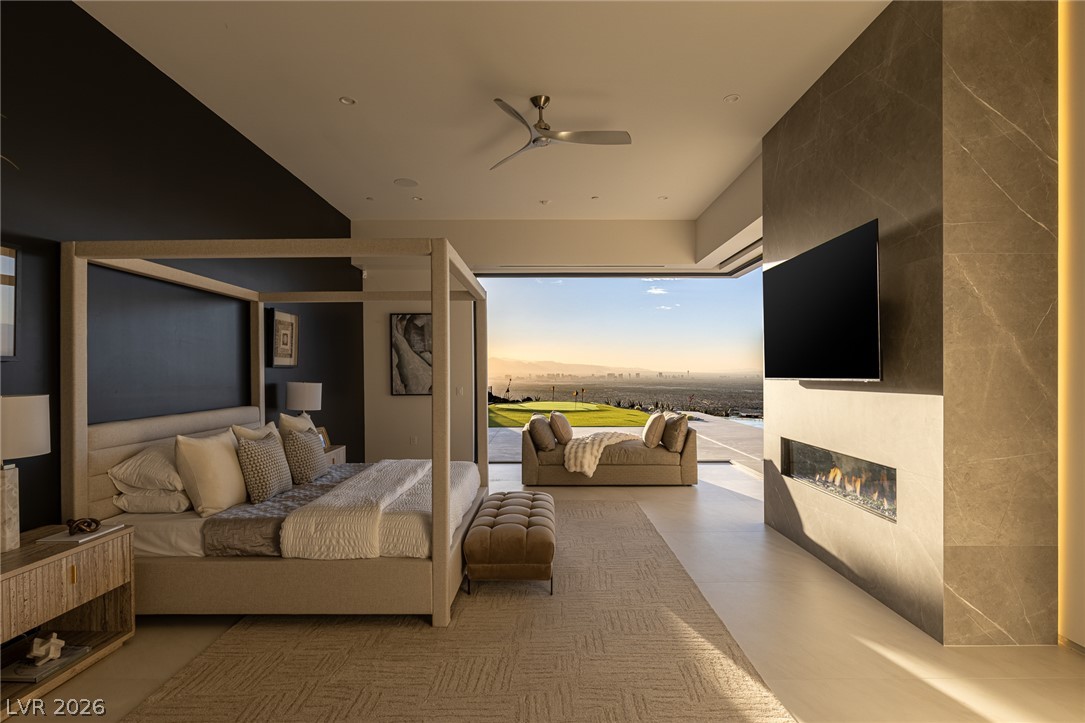 563 Grand Rim Drive Henderson, NV 89012 - Photo 21 of 70 Retreat to this primary bedroom offering a cozy fireplace and panoramic views of the city.