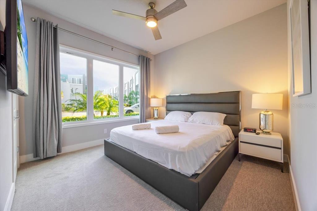 7770 Sandy Ridge Drive, Unit 144 Reunion, FL 34747 - Photo 14 of 22 a bed sitting in a bedroom next to a large window with a balcony lamp