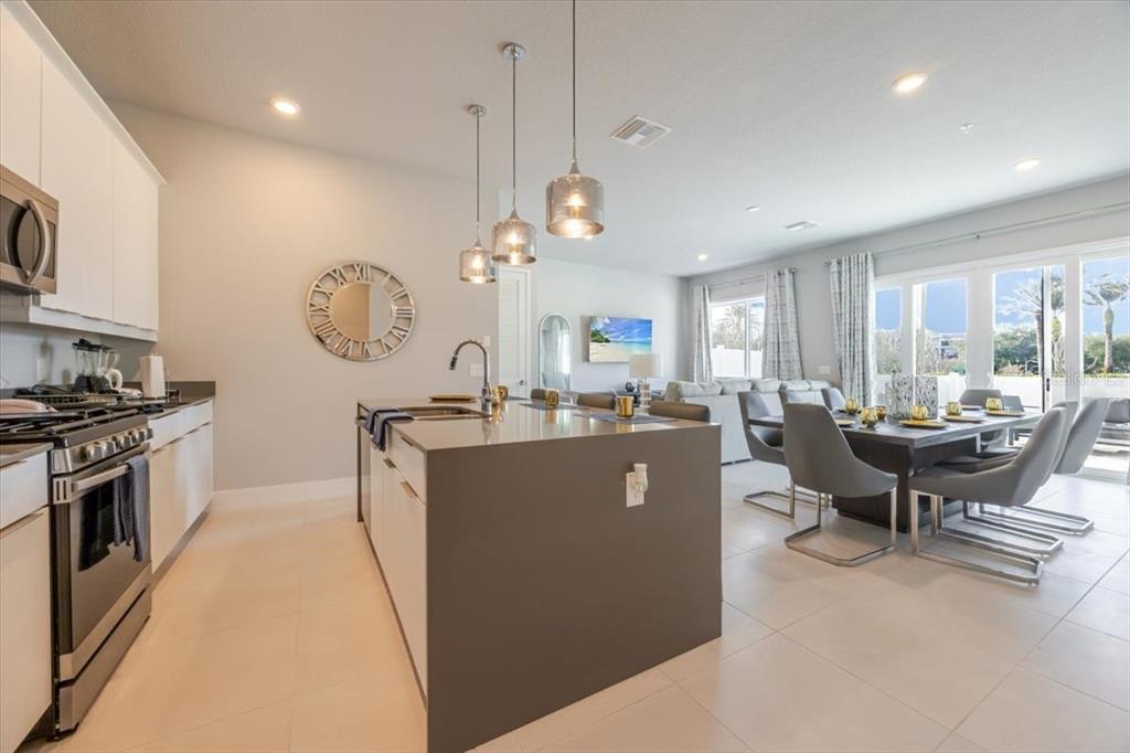 7770 Sandy Ridge Drive, Unit 144 Reunion, FL 34747 - Photo 3 of 22 a living room with couches a dining table kitchen view and kitchen view