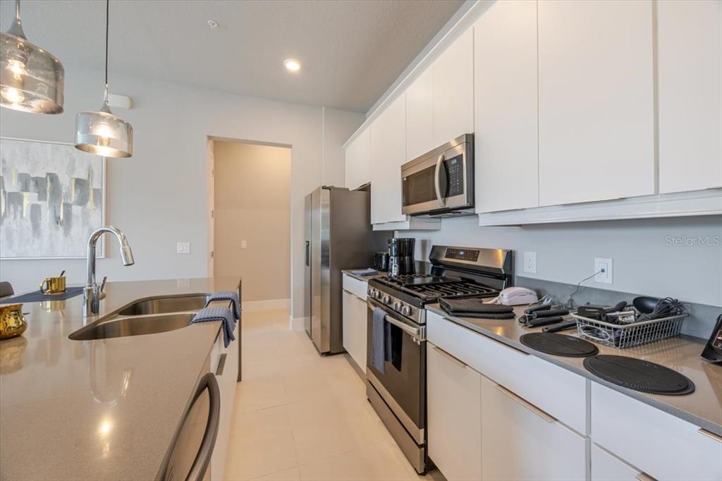 7770 Sandy Ridge Drive, Unit 144 Reunion, FL 34747 - Photo 4 of 22 a kitchen that has a sink stainless steel appliances and cabinets