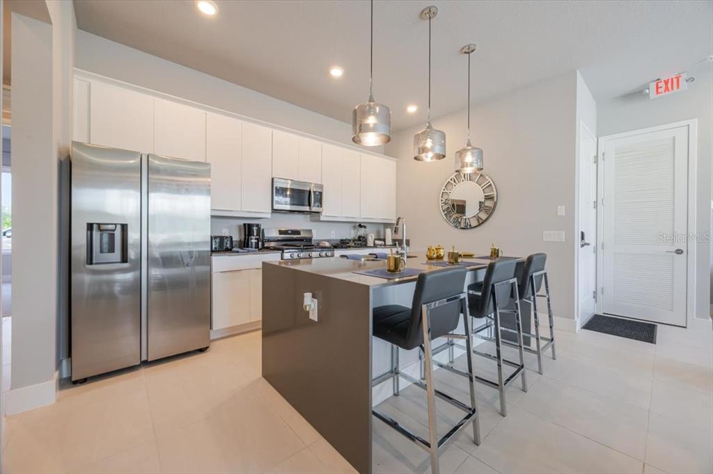 7770 Sandy Ridge Drive, Unit 144 Reunion, FL 34747 - Photo 5 of 22 a kitchen with kitchen island a counter top space appliances and cabinets