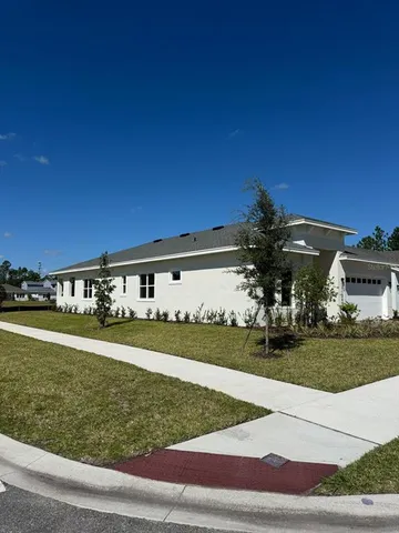 a view of a house with a yard and a garage