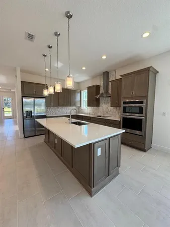 a large kitchen with stainless steel appliances and a sink