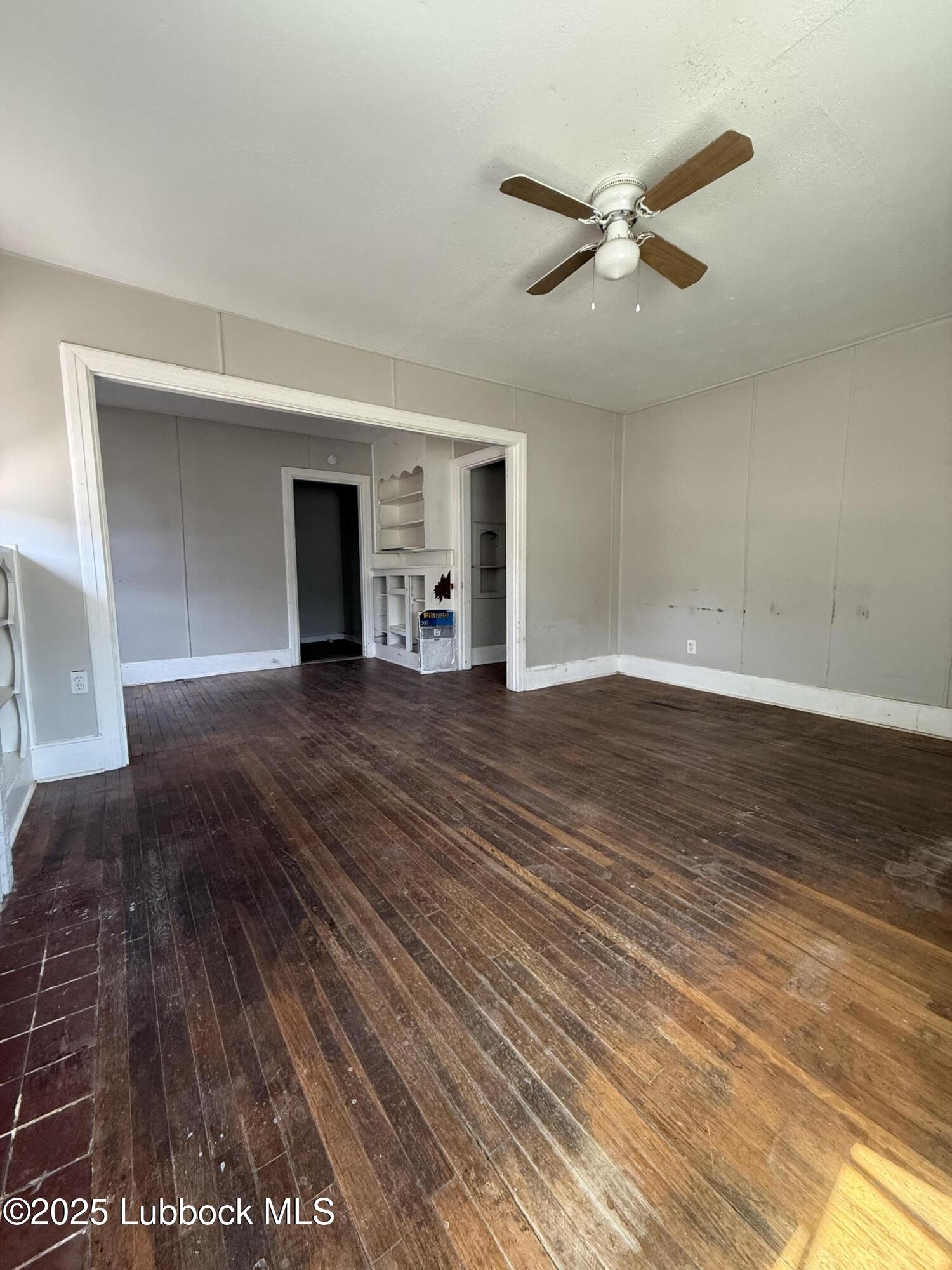 2116 20th Street Lubbock, TX 79411 - Photo 3 of 7 a view of a livingroom with a hardwood floor and a ceiling fan