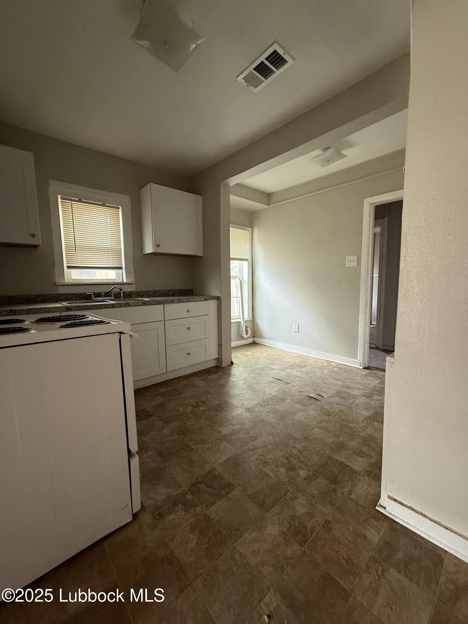 2116 20th Street Lubbock, TX 79411 - Photo 5 of 7 a kitchen with stainless steel appliances granite countertop a stove a sink and a refrigerator