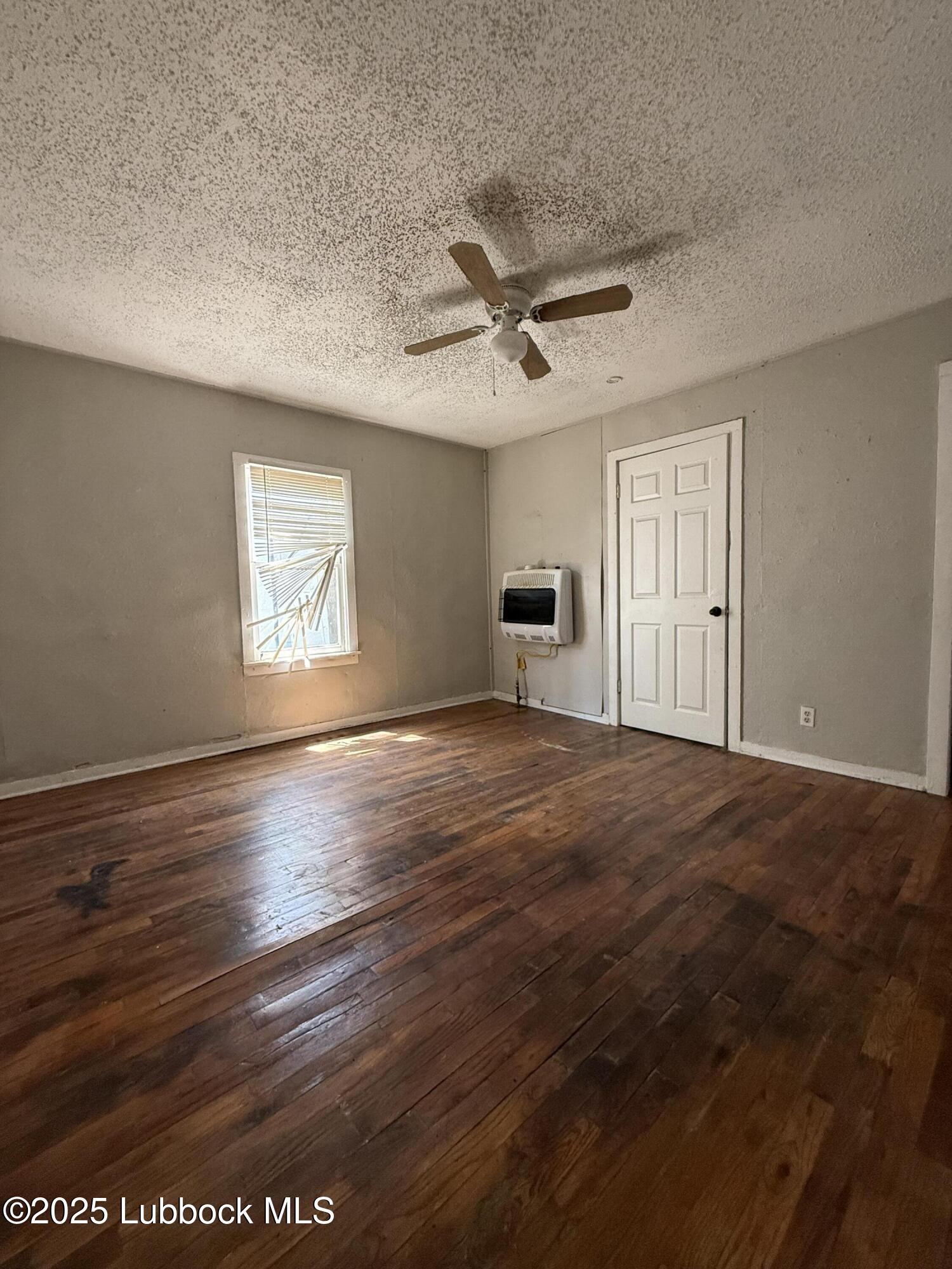 2116 20th Street Lubbock, TX 79411 - Photo 6 of 7 a view of empty room with wooden floor and fan